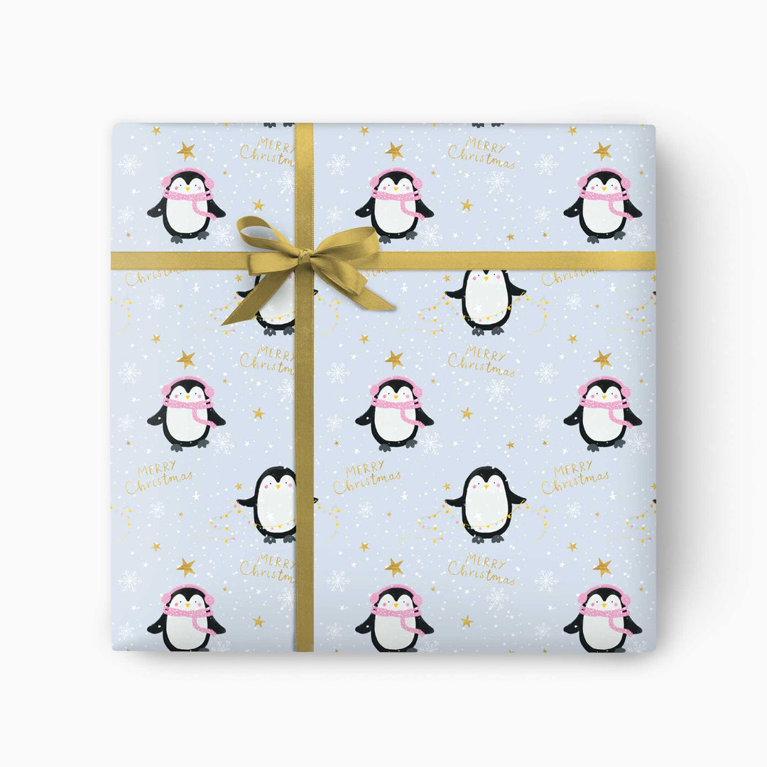 Penguin Christmas wrapping paper with scarved penguins and snowy stars